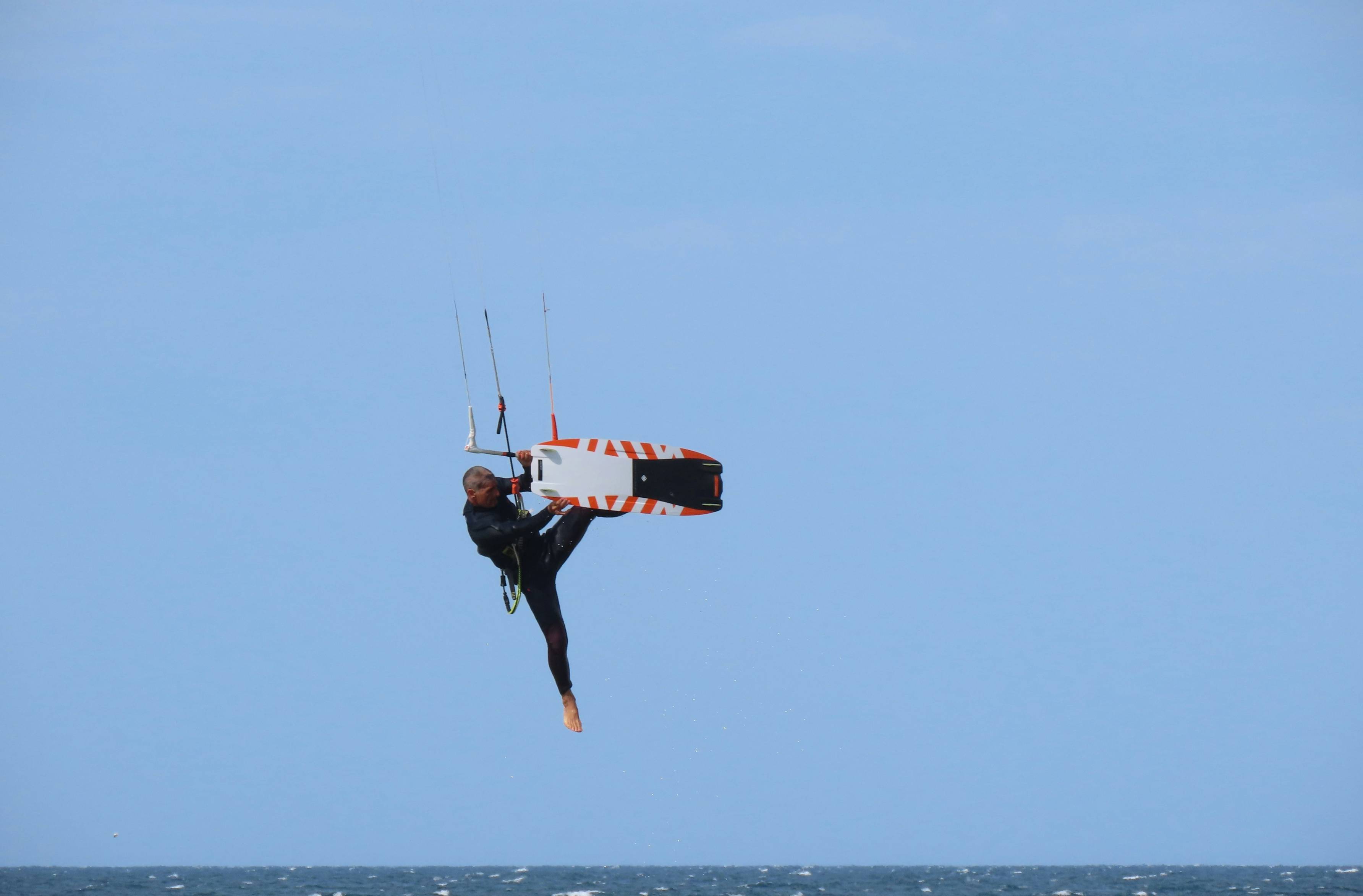 a man on a surfboard in the air over the ocean