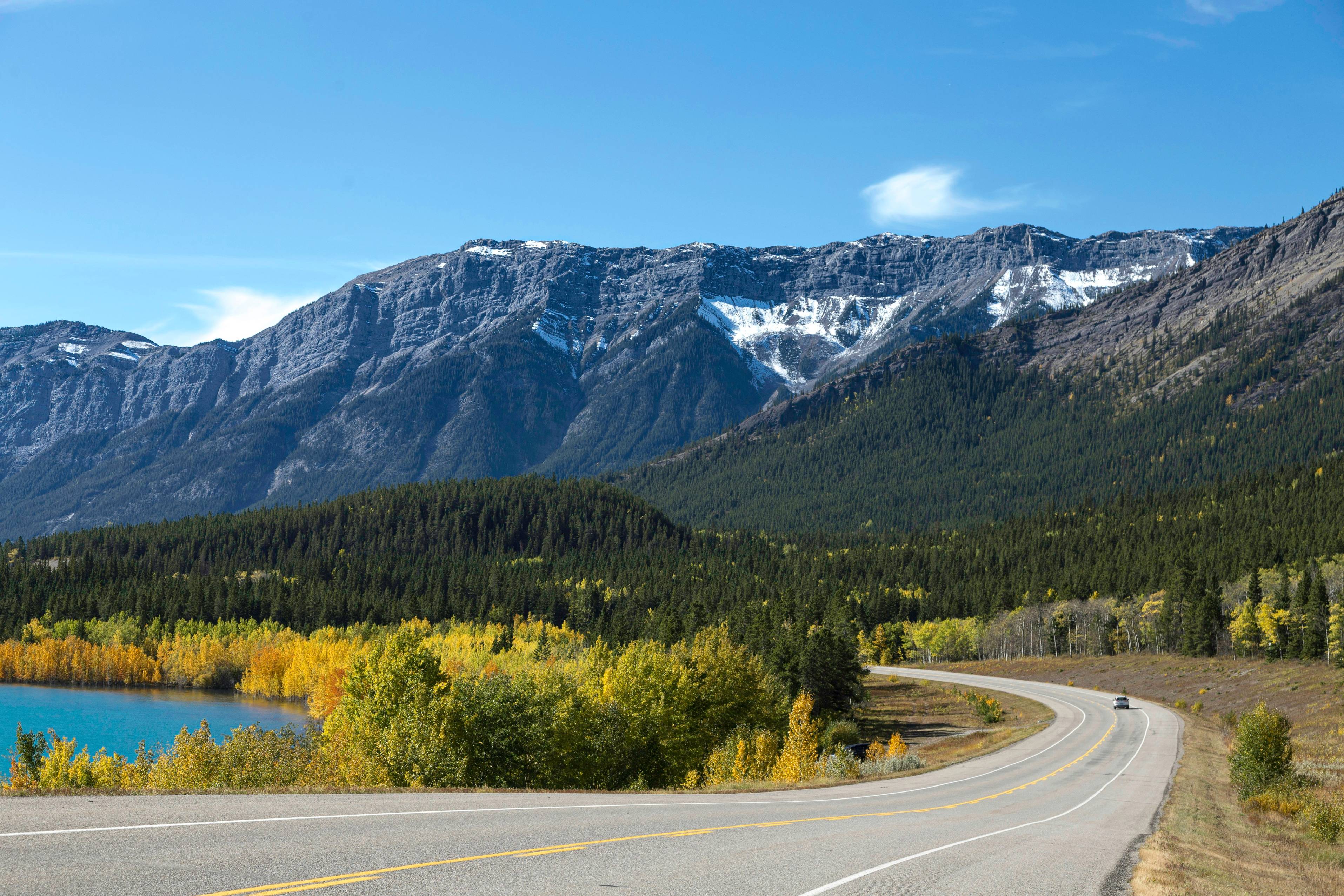 a scenic view of a mountain range with a lake in the foreground
