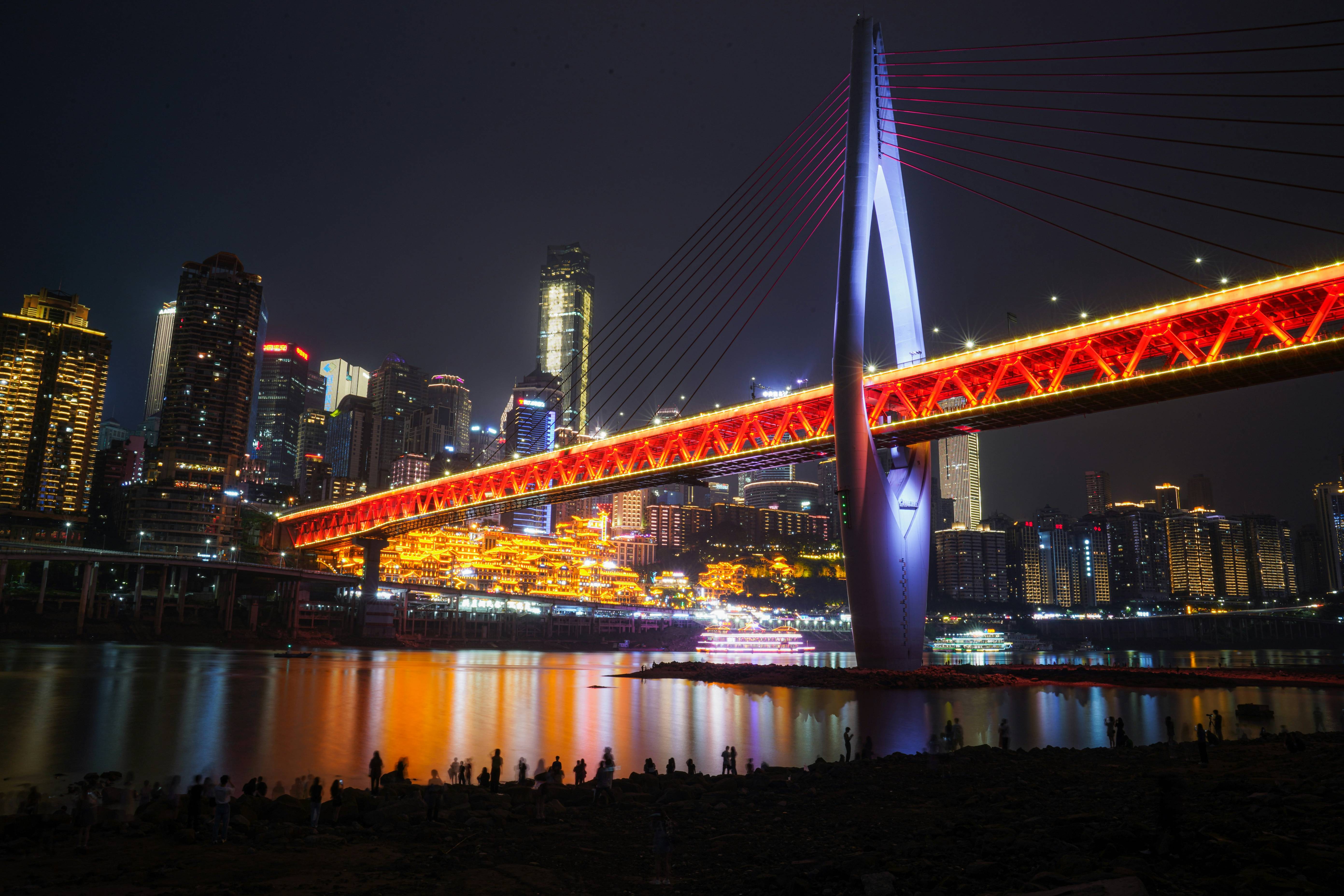 A large red bridge spanning over a large body of water