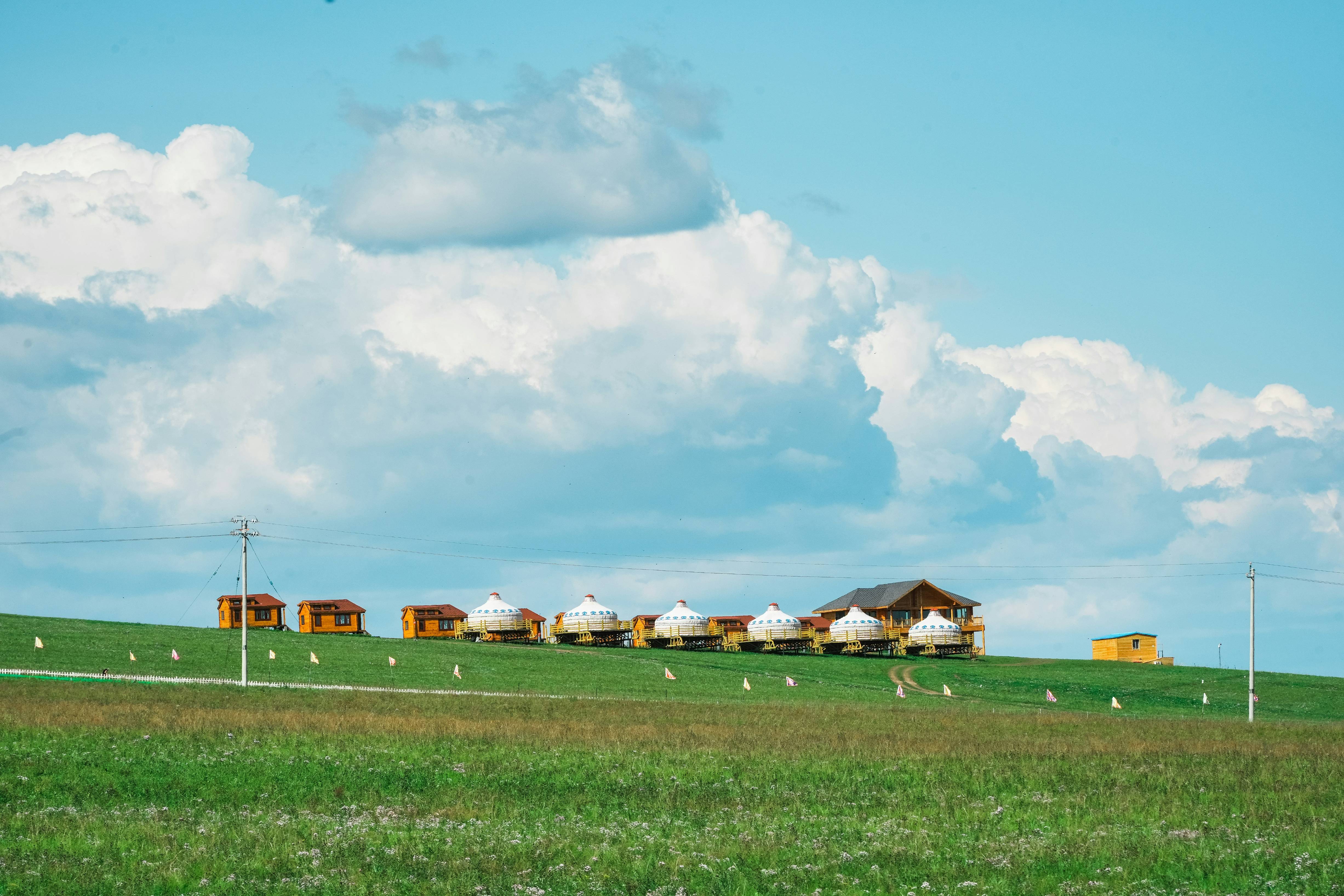 a green field with a house in the distance